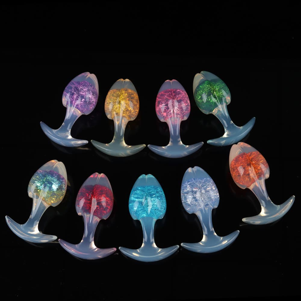 Nine beautifully styled crackle-interior plugs with glowing opal stems, arranged in two neat, alternating rows to highlight the rich variety of colors.
