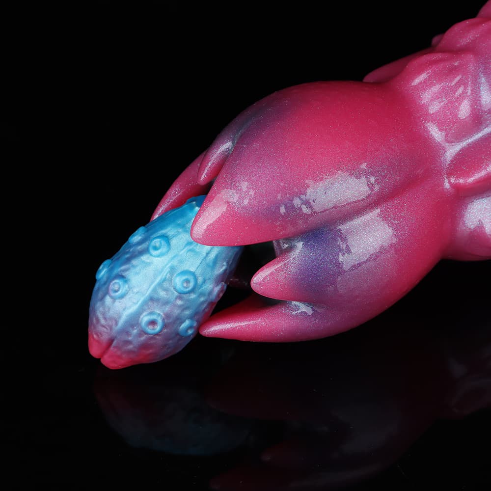 Extreme close-up of the magenta petal-shaped opening of the alien ovipositor dildo holding a blue textured egg refill, demonstrating the realistic internal delivery mechanism.