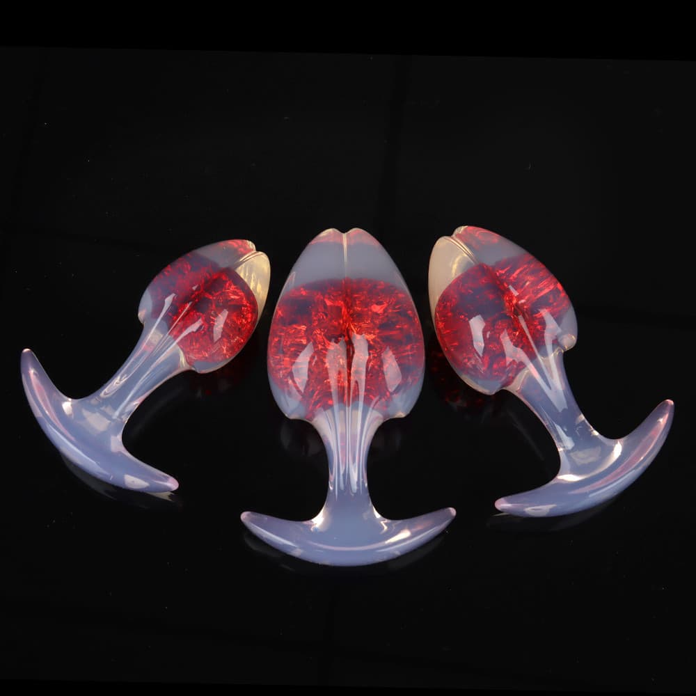 Three deep aurora red crackle-interior plugs with translucent opal shafts and flared safety bases, perfect for temperature play.