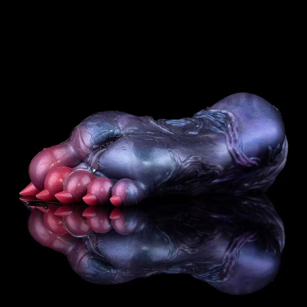 Side profile of beast paw male stroker reflecting on a sleek black surface.