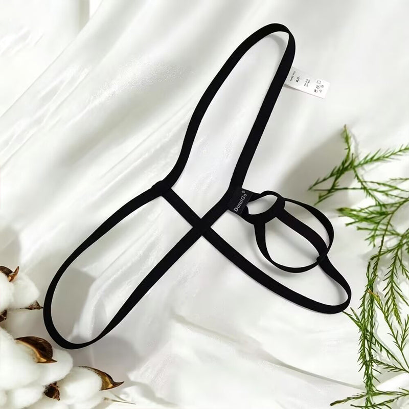Black open-back pouch thong jockstrap for men with flexible side straps laid over a white silk background.
