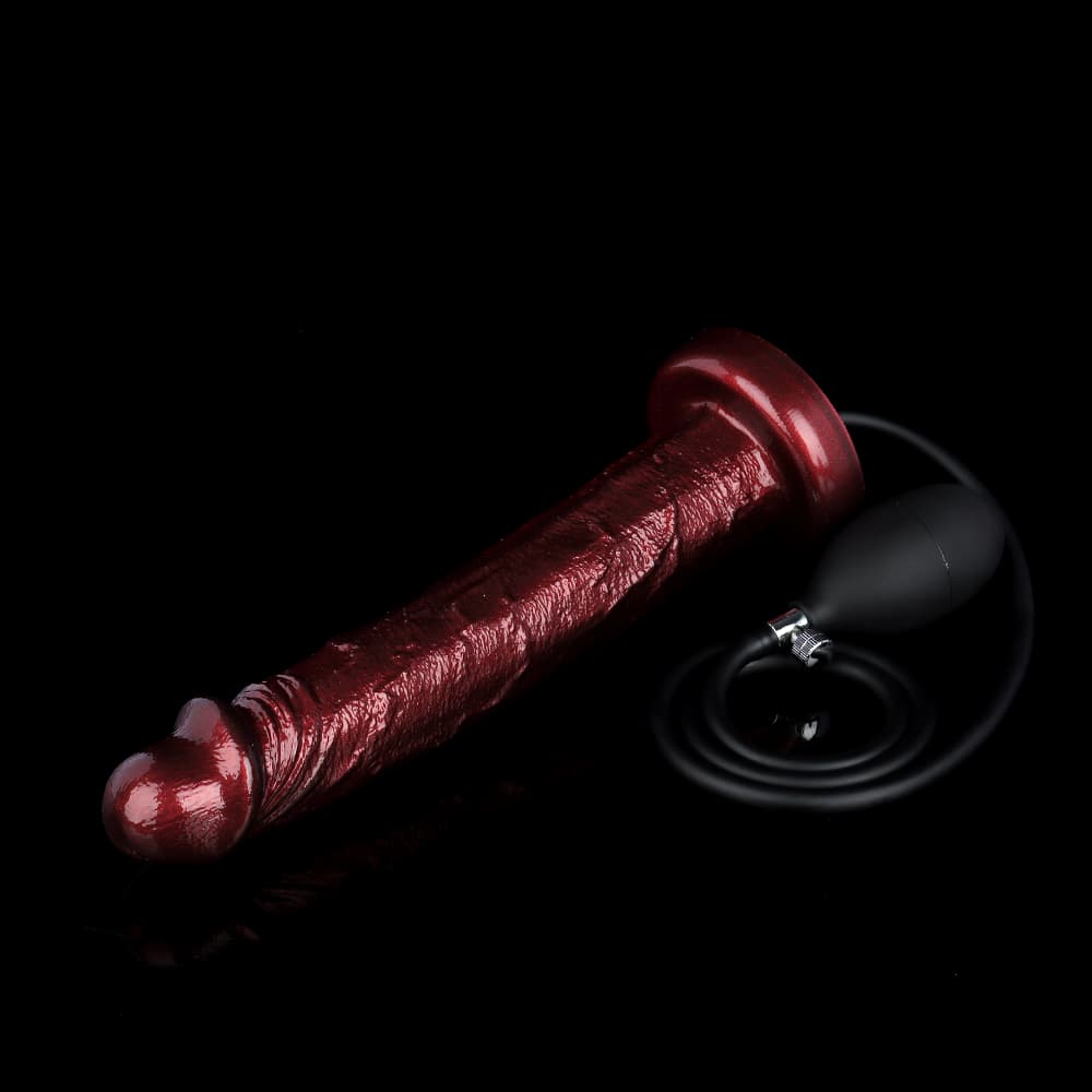 The large burgundy inflatable suction cup dildo lying horizontally next to the black hand pump.