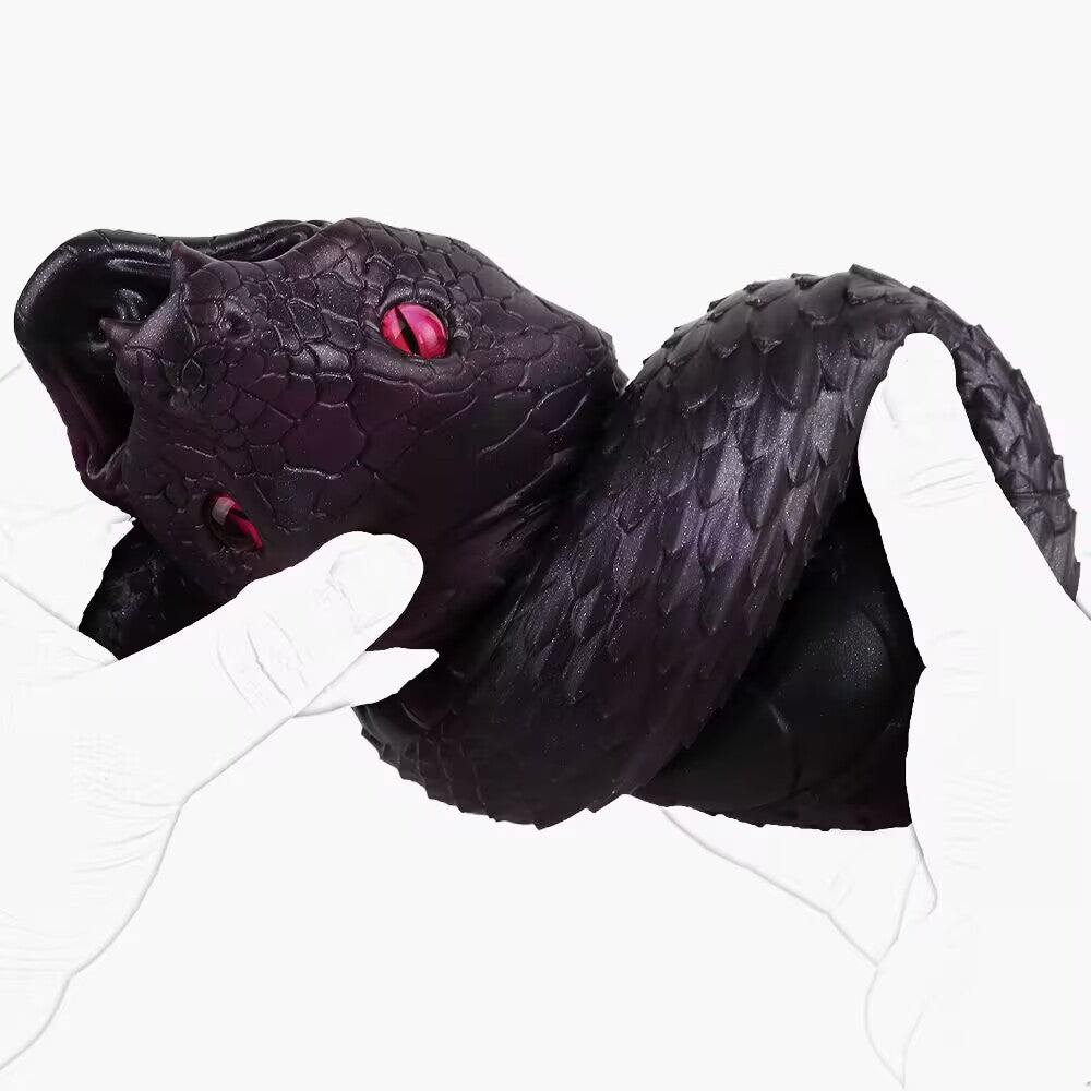 Hands holding coiled purple silicone dark snake male masturbator with red eyes and detailed scales