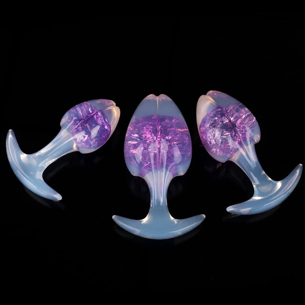 Three mystical cosmic violet purple crackle-core plugs, elegantly styled with opal-sheen handles on a polished black display.