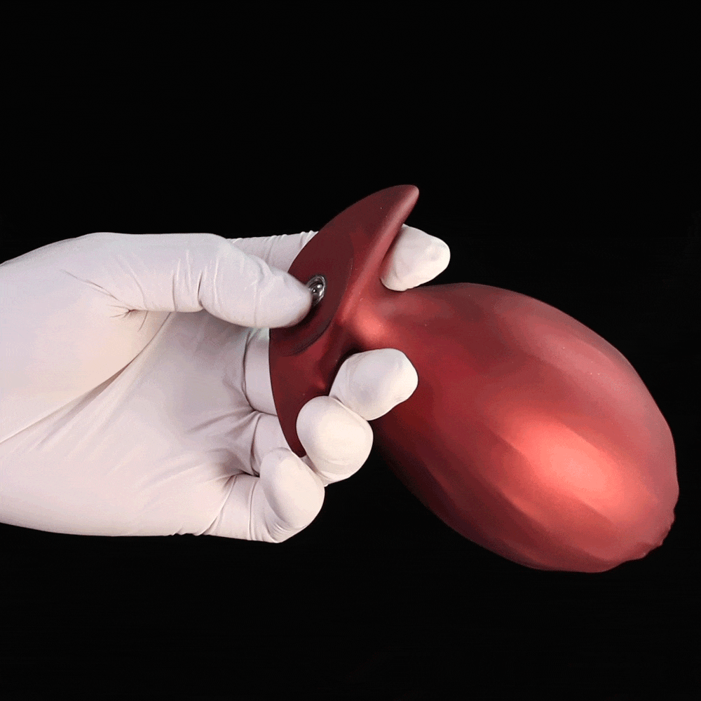 Crimson red inflatable textured silicone butt plug with premium matte shimmer finish and detailed ribbed scales for internal stimulation.