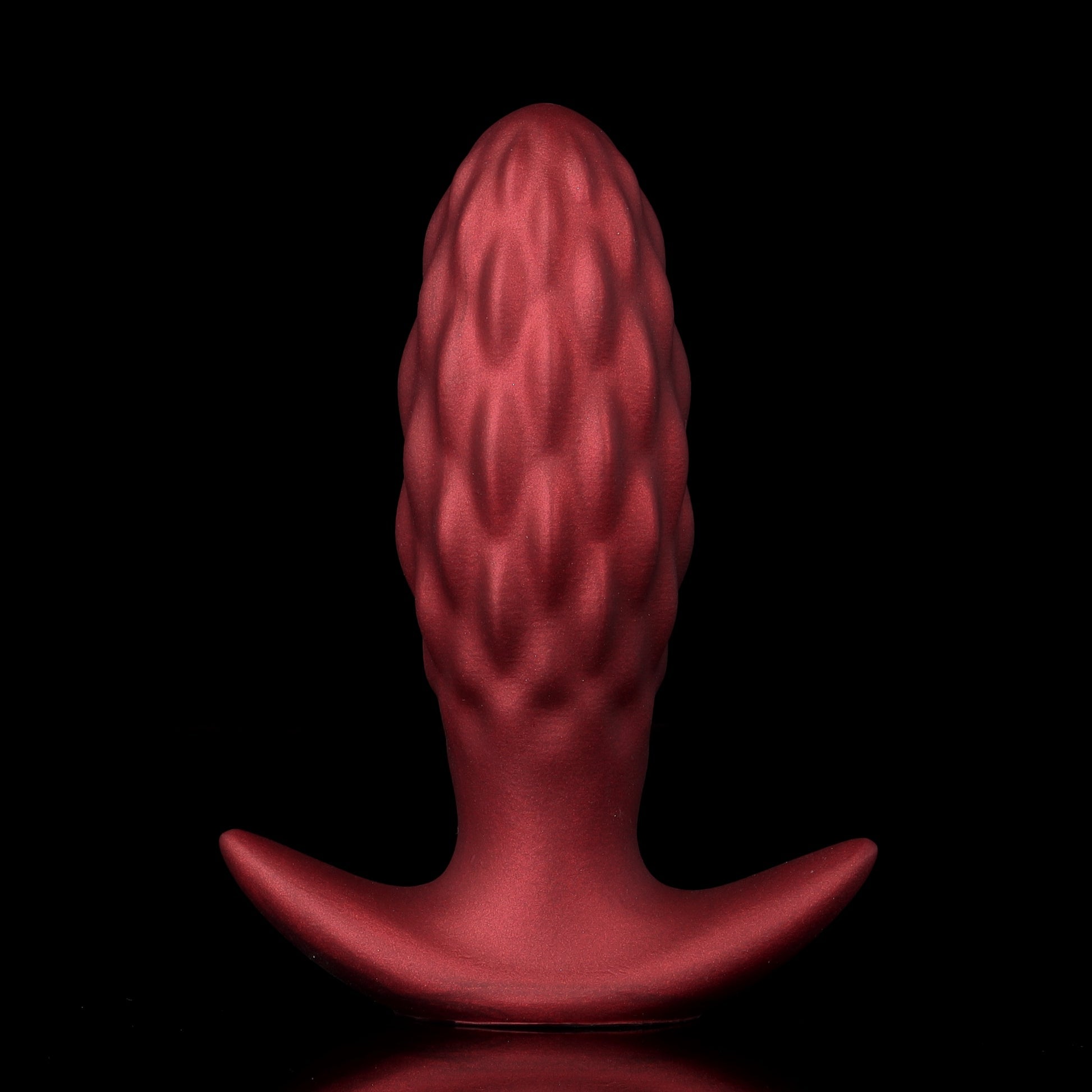 Crimson red inflatable textured silicone butt plug with premium matte shimmer finish and detailed ribbed scales for internal stimulation.