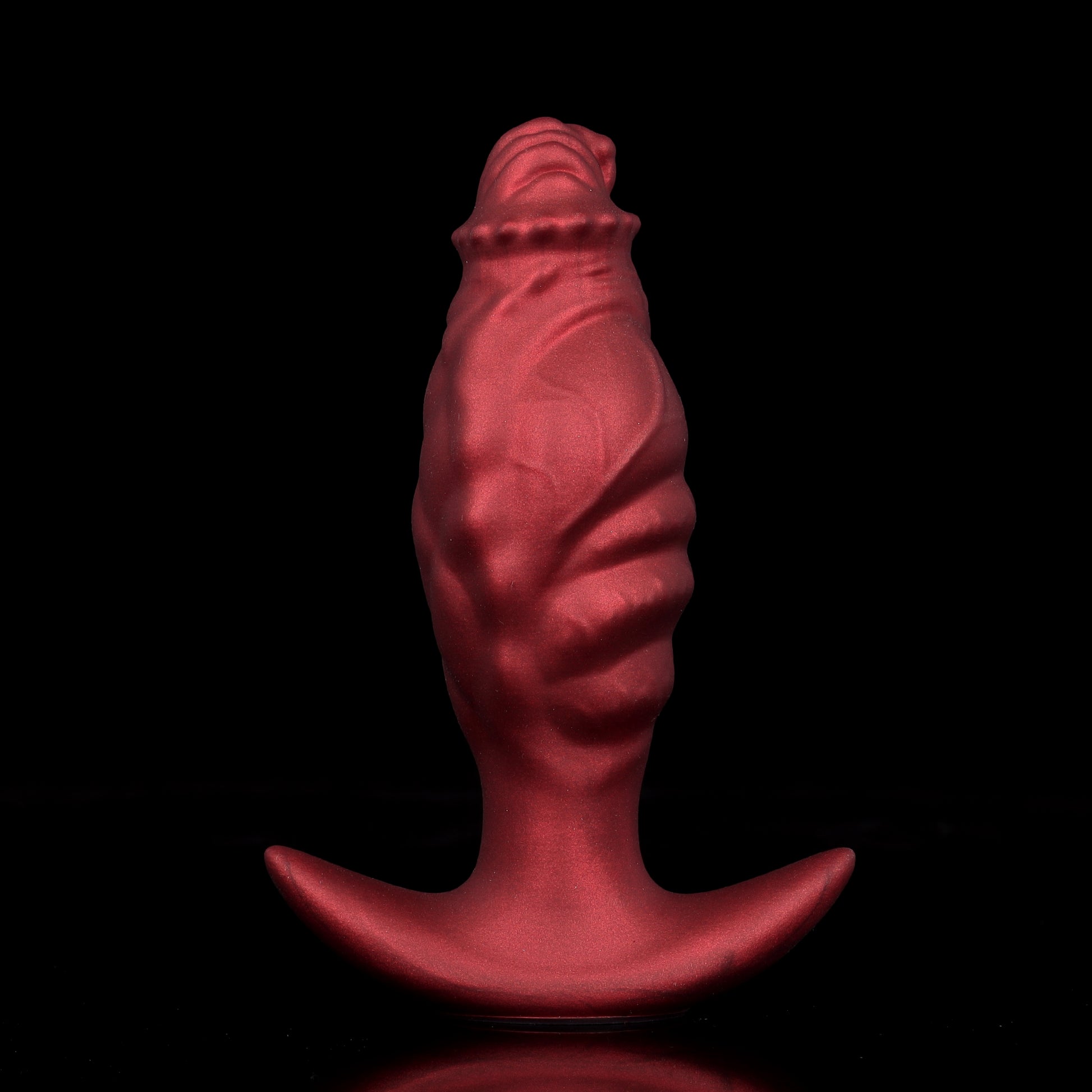 Front profile of a matte crimson red fantasy tentacle anal plug in a deflated state, highlighting the deep organic ribbed ridges.
