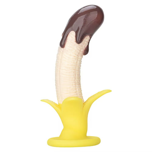 Side view of a curved banana silicone dildo with dark chocolate drip design and yellow peel suction base.