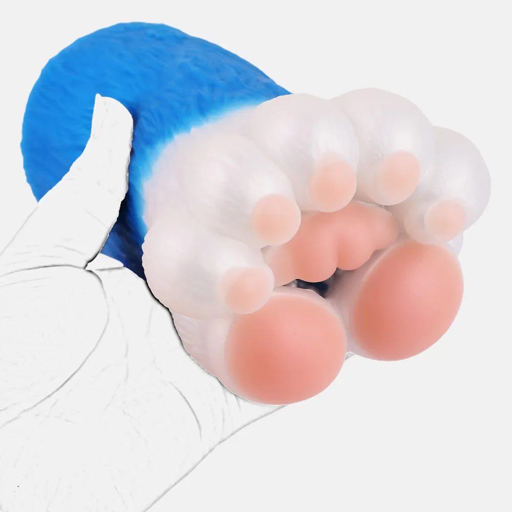 A hand holding a blue and white anime-style cat paw male stroker toy showing soft pink paw pads and squishy claws.