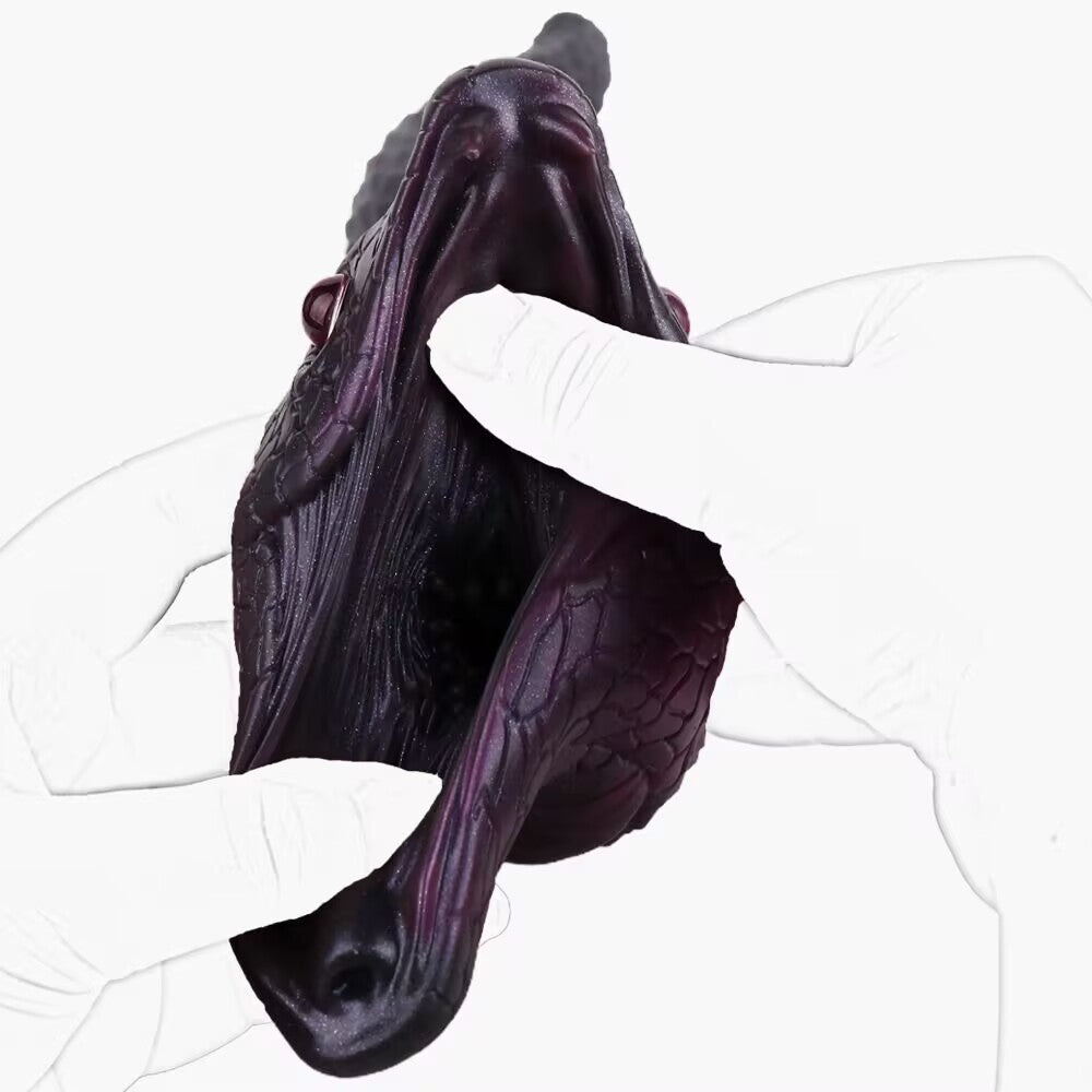 Hands opening the mouth entry of dark snake silicone fantasy stroker showing inner ribbed canal