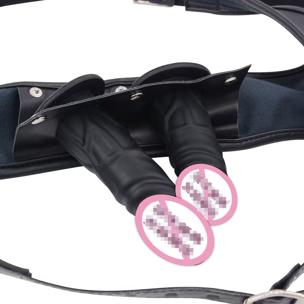 Close-up view of dual detachable dildos securely fitted into a black leather harness plate with metal snaps