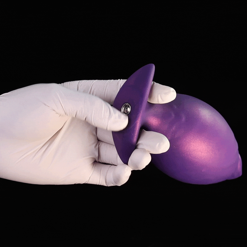 A gloved hand demonstrating the texture of the Royal Purple inflatable fantasy butt plug before inflating.