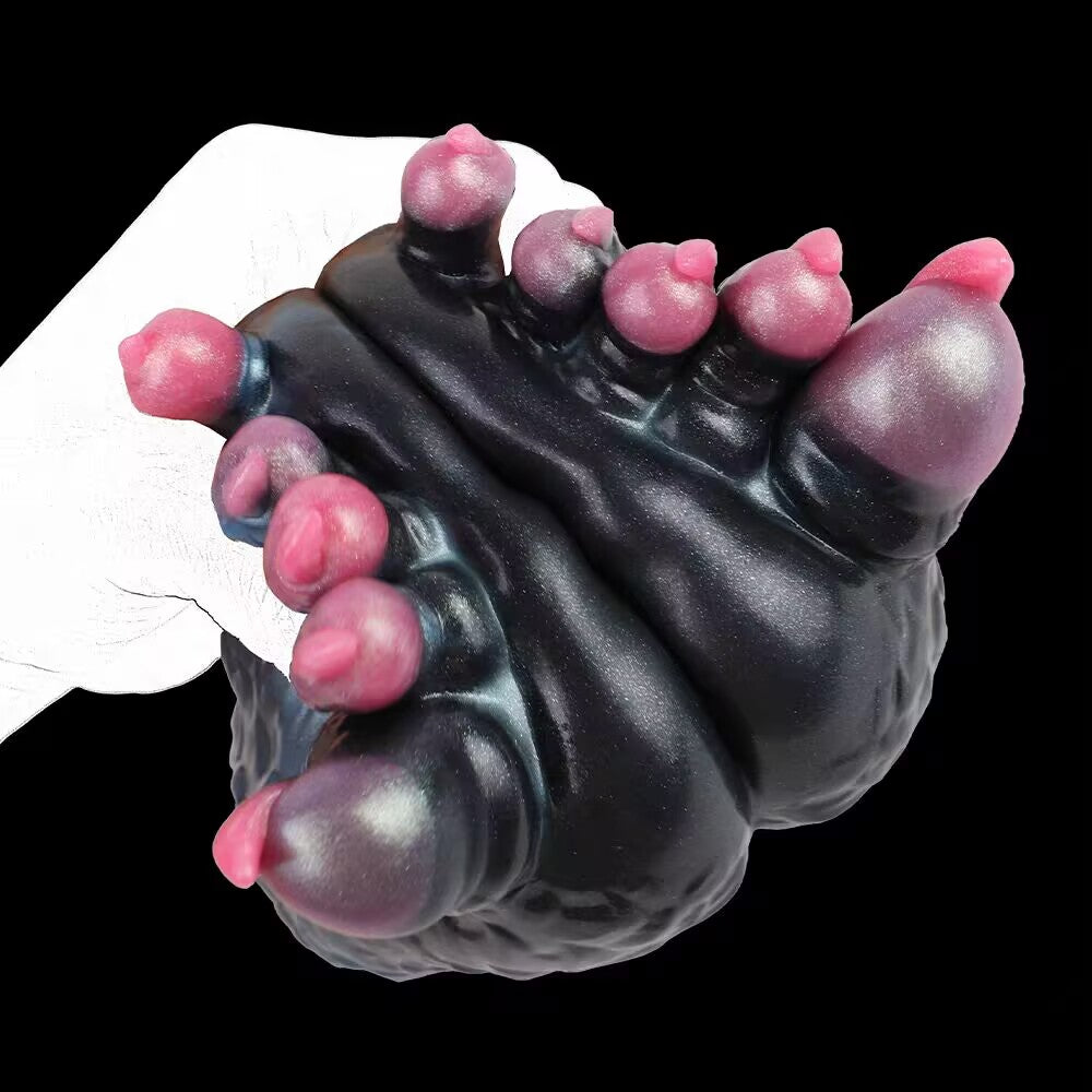 Close-up view of the hand-held fantasy male masturbator highlighting the vibrant pink claws and high-quality textured silicone surface.