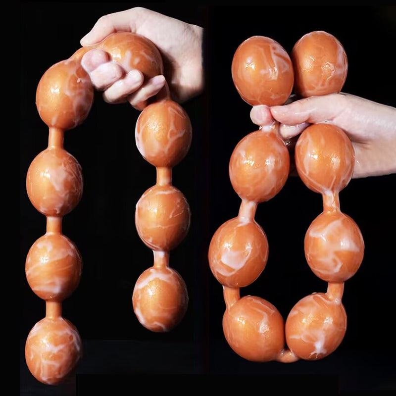 Hands bending and pulling long flexible silicone beaded anal plug showing high elasticity for couple tug play.