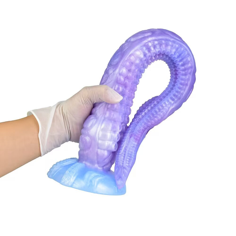 A hand in a white glove demonstrating the extreme flexibility and softness of the purple silicone tentacle toy by bending it into a U-shape.