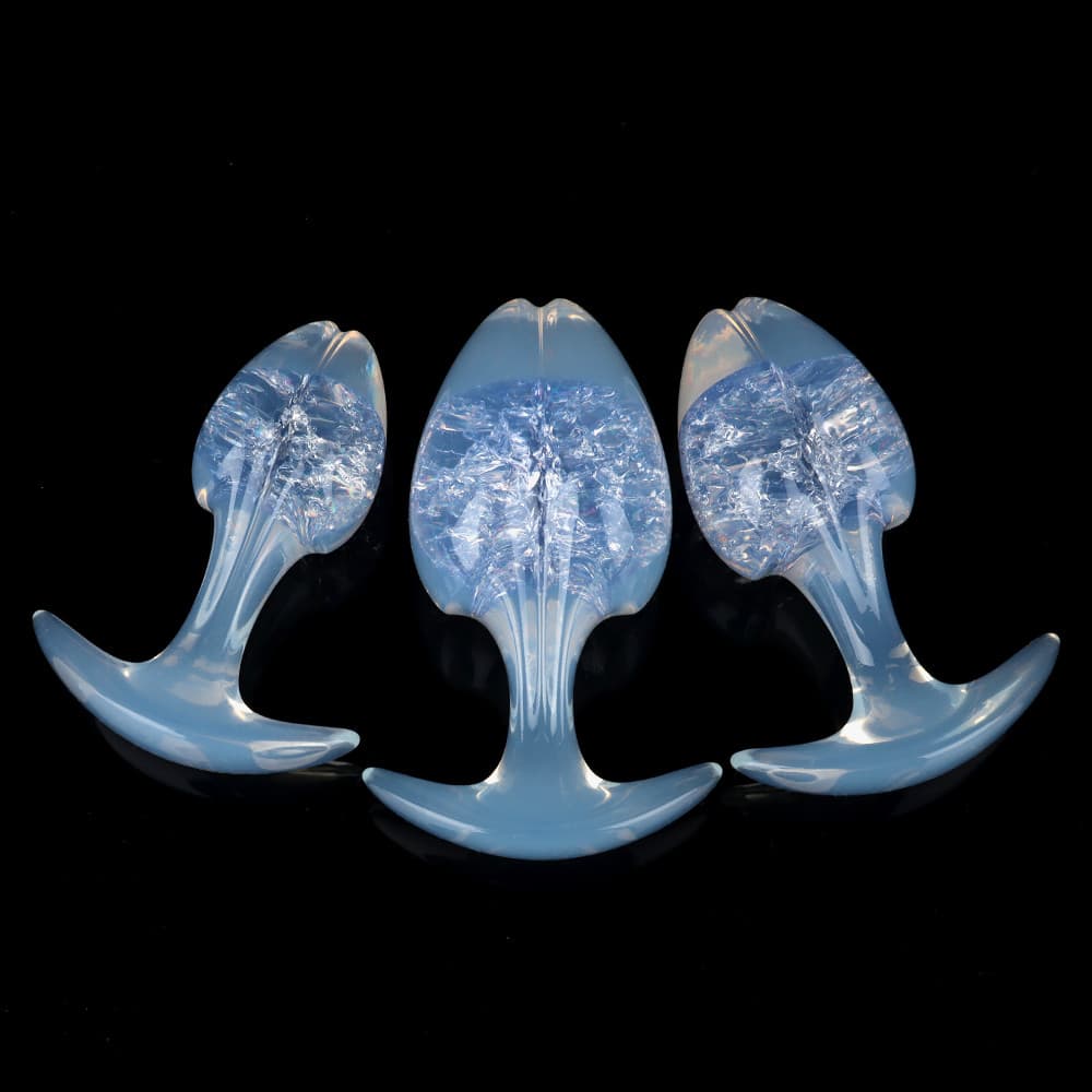 Three ice-cold frozen blue crackle-core plugs with shimmering crystalline patterns inside and semi-translucent blue-tinted opal bases