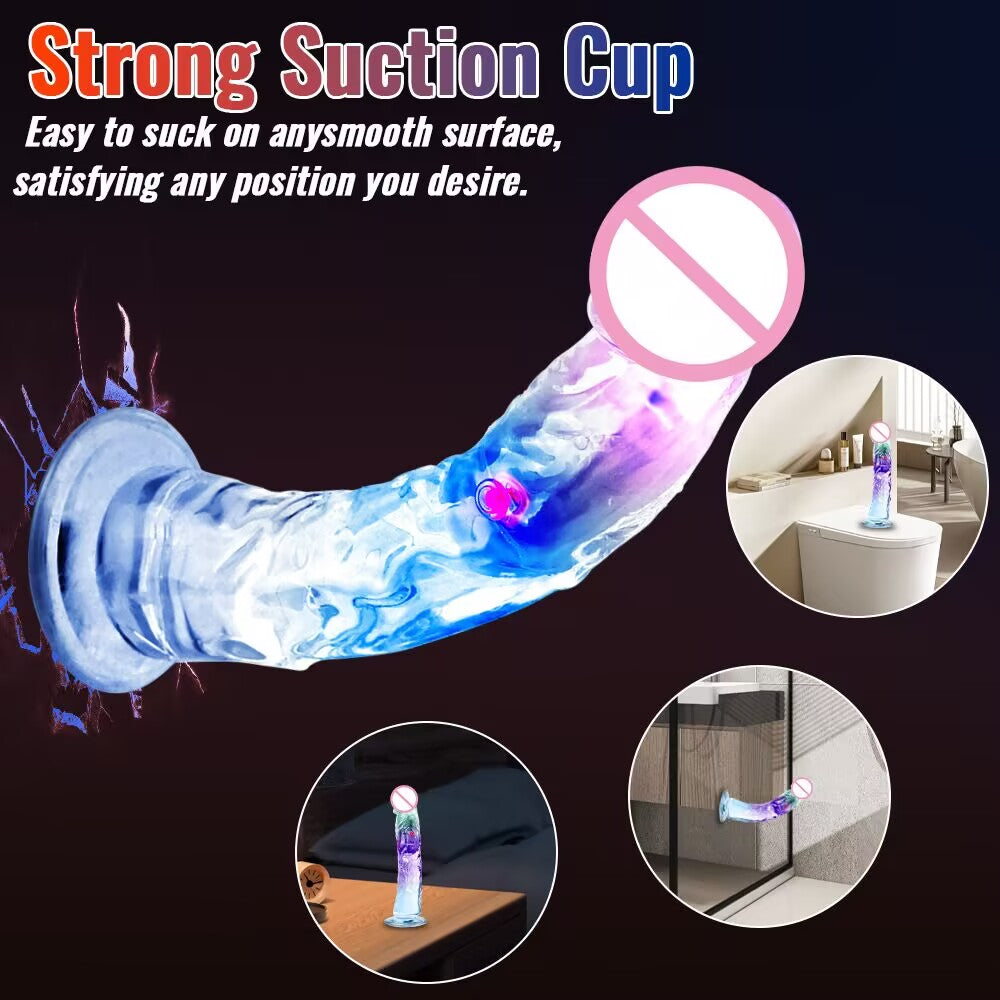 Glowing crystal vibrating dildo with strong suction cup base mounted on smooth bathroom tile surface.