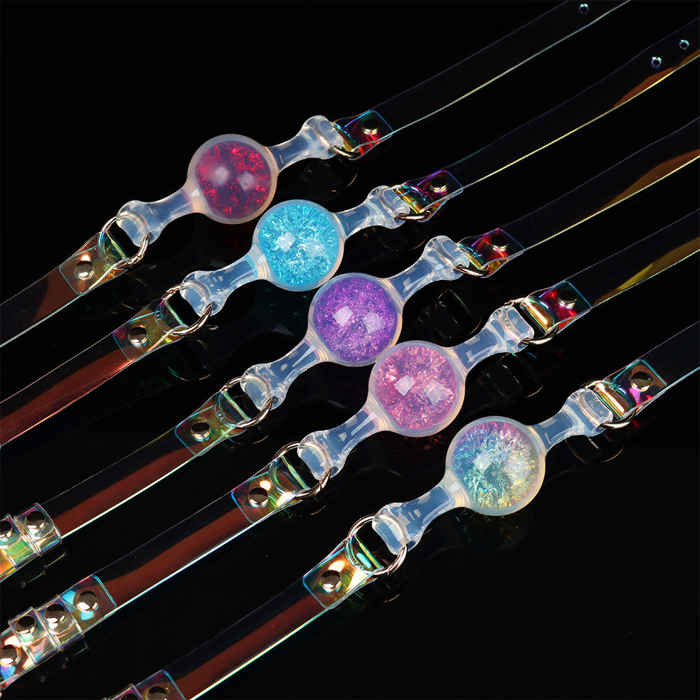 Five colorful glitter crystal ball gags with iridescent laser straps arranged neatly in rows against a sleek black background.