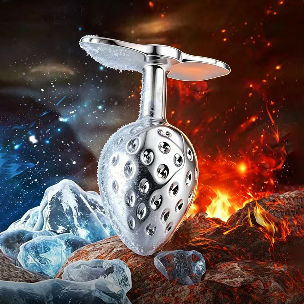 A metallic strawberry butt plug splitting an element of frost and flames, highlighting its temperature play capabilities for hot and cold sensations.