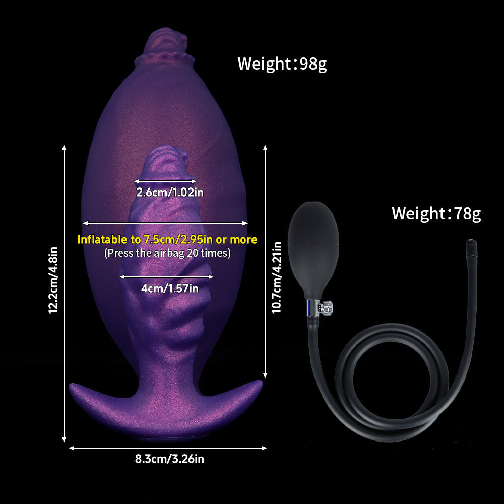 A frontal view of a deflated purple fantasy butt plug with complex textures, standing upright on a reflective black surface.