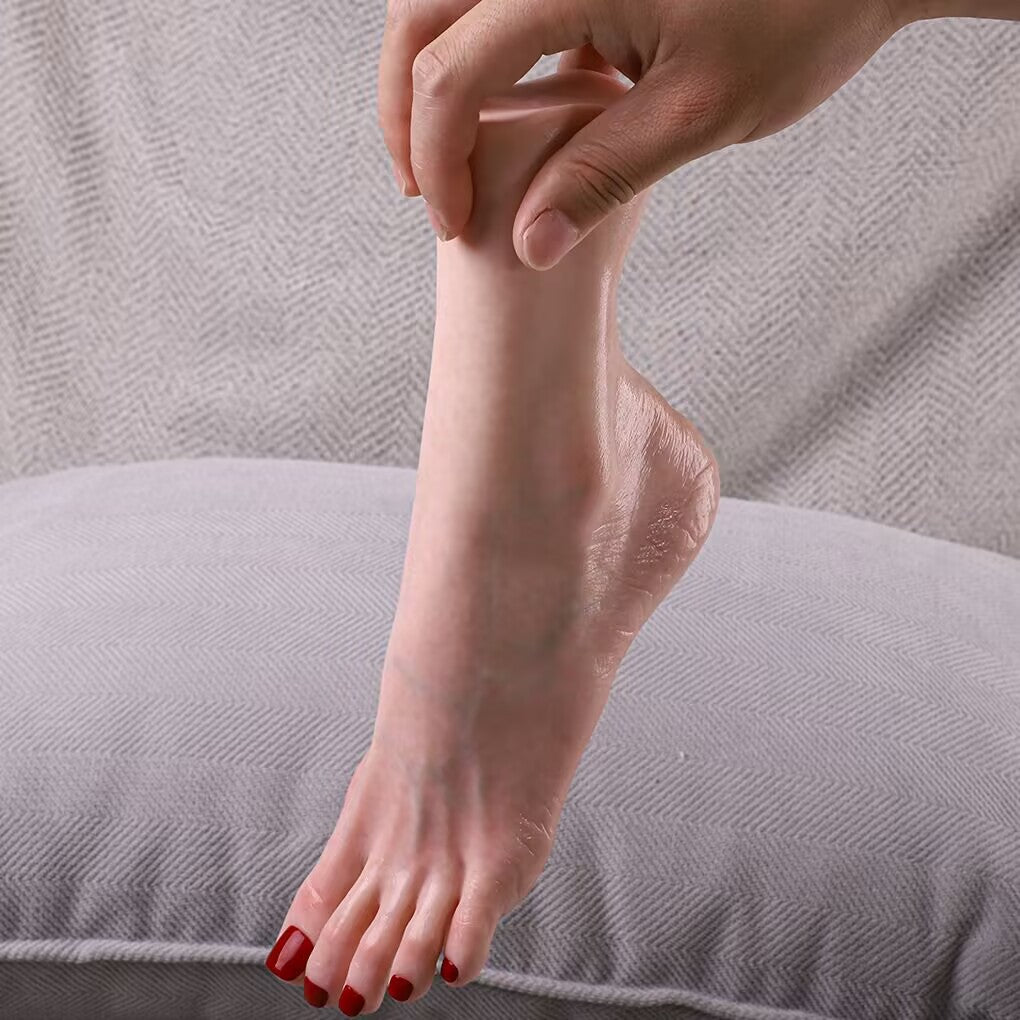 Hand holding a life-size silicone foot model showcasing natural ankle flexibility and arch contour for nail and jewelry display.