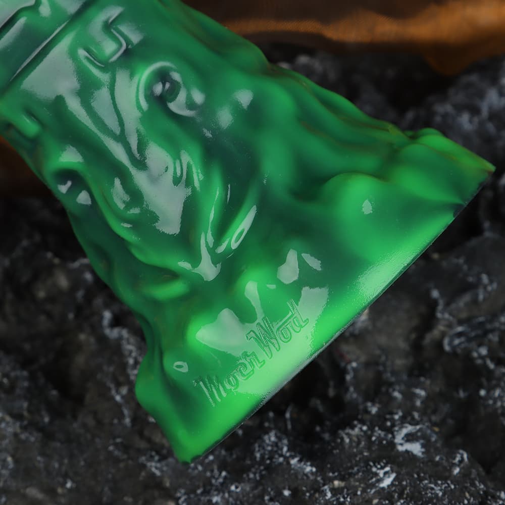 Close-up of the Moon Wood brand logo engraved on the green body-safe silicone base of the inflatable monster toy.
