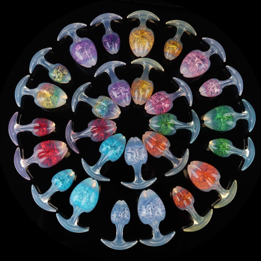 A spectacular concentric circle showcase of opal-glow crackle plugs in various vibrant colors, perfectly displayed on a glossy black reflective background.