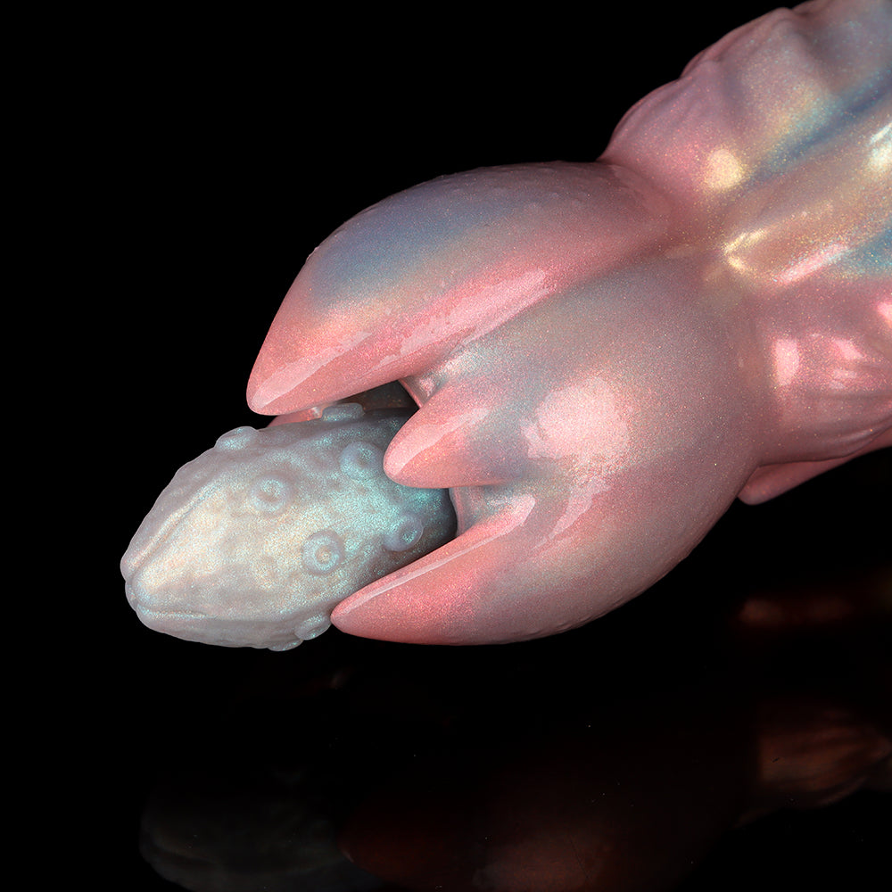Close-up macro view of a textured light blue fantasy silicone egg being inserted into the blooming blooming-petal style tip of a pink pearlescent alien ovipositor toy.