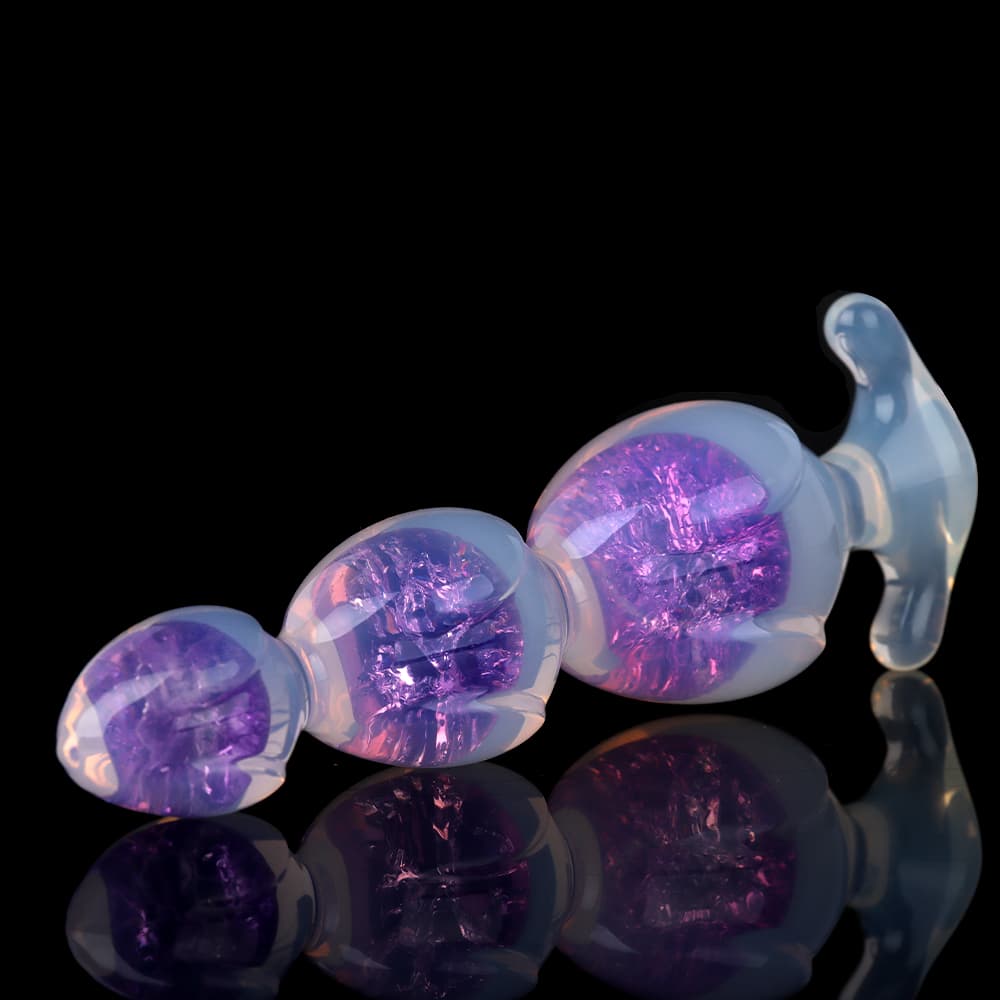 Premium purple jelly silicone anal toy lying flat on a reflective surface showing its elegant body contour.
