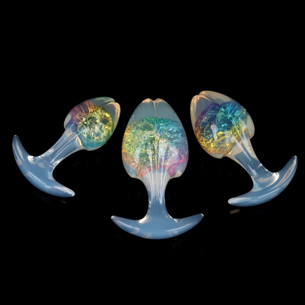 Three rainbow-colored prism plugs with mesmerizing color-shifting crackle effect cores and smooth semi-translucent opal handles showcased on a black reflective background.