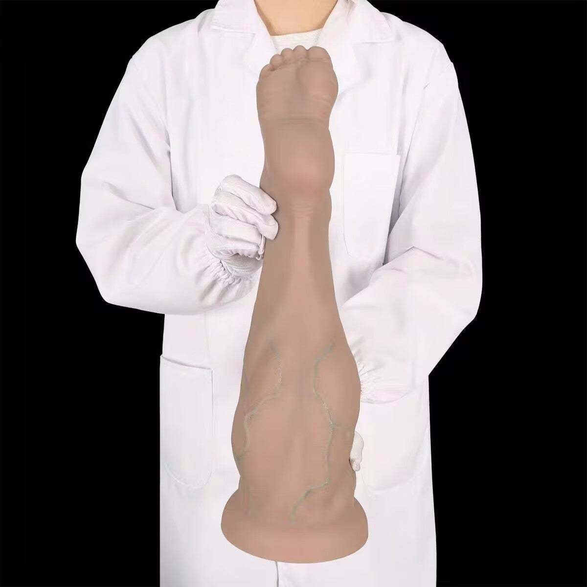 Model holding a realistic silicone foot butt plug vertically to demonstrate real-life scale and vein detail.