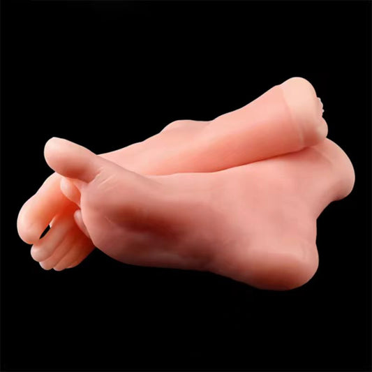 A pair of life-sized silicone foot display models crossed over on a solid black background, showing realistic sole and toe details.