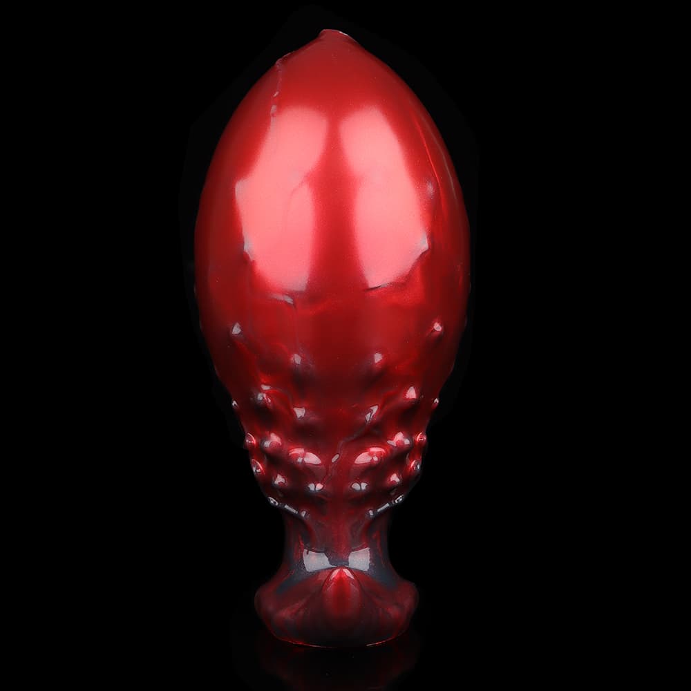 The smooth back view of a metallic red ombre monster dildo, highlighting its unique ergonomic shape and flared safety base.