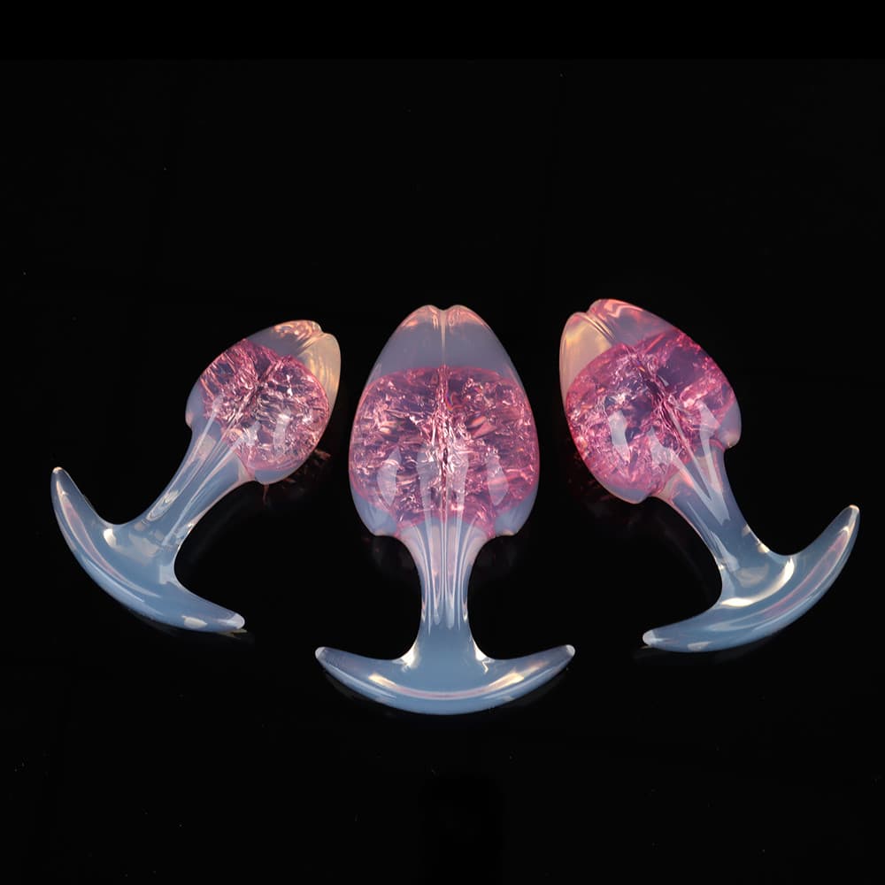 Elegant set of three rose pink glimmering crackle-core plugs with soft white-opal translucent handles for sensory pleasure.