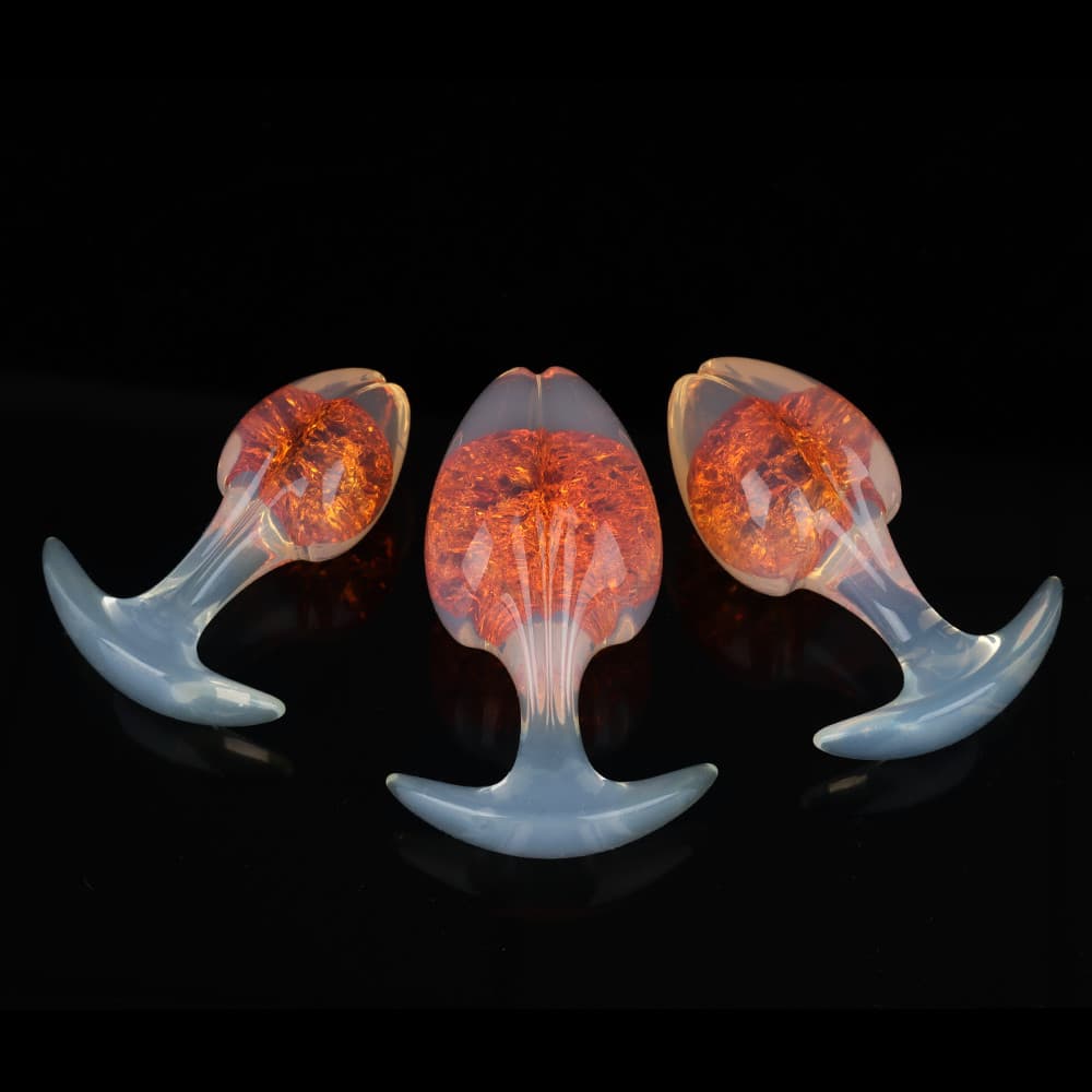 Three solar amber orange crackle-effect plugs showing different angles of the flared T-bar safety base and smooth tapered tip.