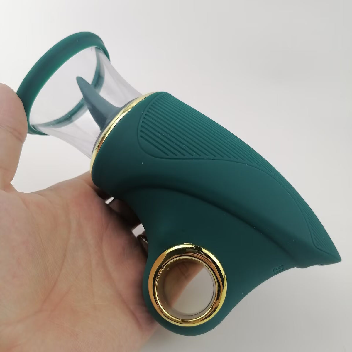 Handheld teal and gold intimate massager showing ergonomic ring handle and compact design.
