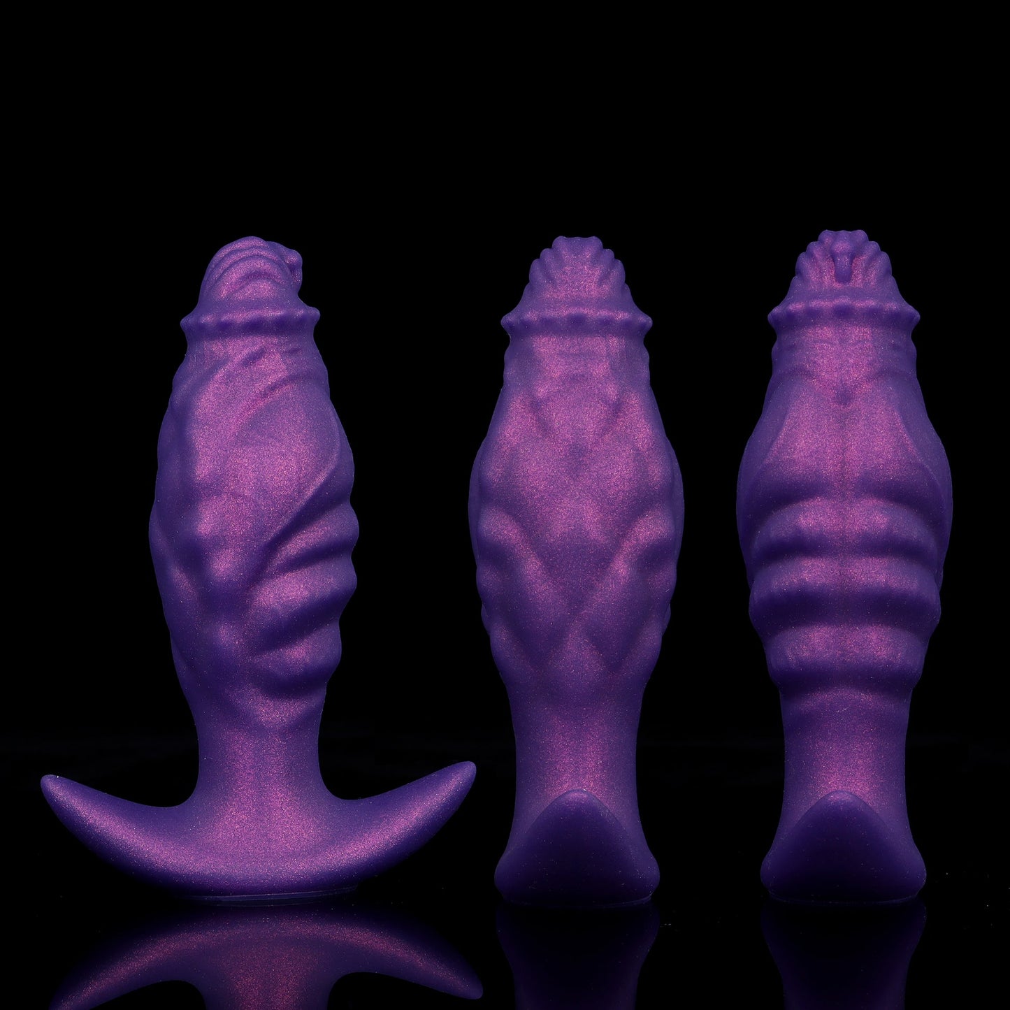 Three purple textured fantasy anal plugs lined up to show the organic undulating ripples from the front, side, and back profiles.