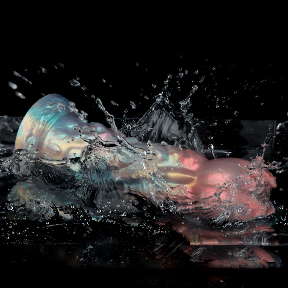 Action shot of the pearlescent silicone monster dildo splashing into clear water on a dark background, demonstrating its 100% waterproof rating for easy cleaning.