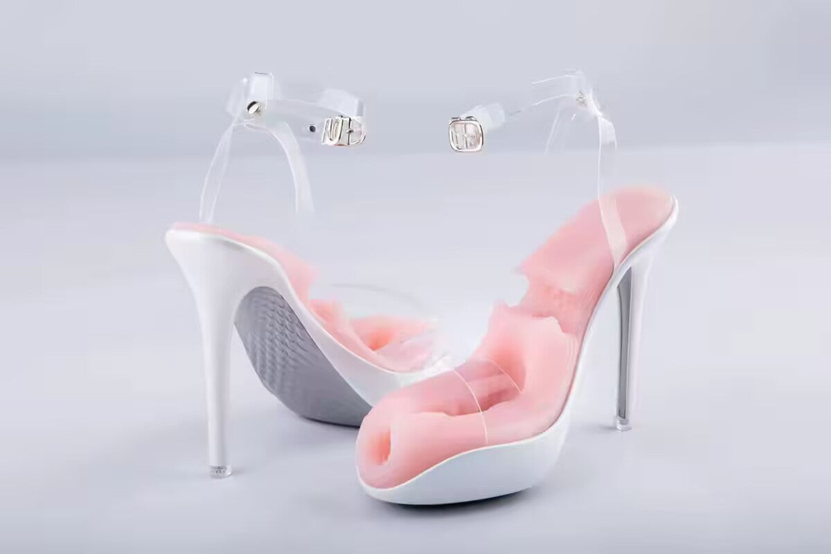 Discreet white high heel sandal adult toy for men featuring transparent straps and a pink textured silicone inner stroker sleeve. Product view from the front and side profile.