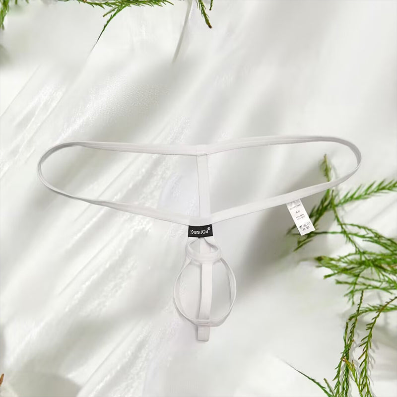 White men’s minimalist open-back pouch thong underwear with dual-ring support laid flat on a soft silk background with botanical accents.